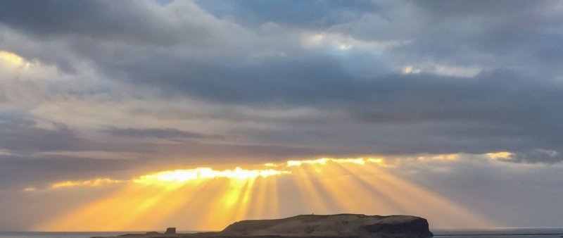 Streans of afternoon light over the island Heimaey
